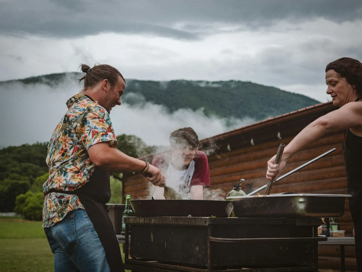 Amigos cocinando en una barbacoa al aire libre